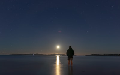 夜间站在海边的人